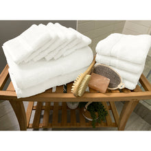 Load image into Gallery viewer, Twelve white towels from the spa collection towels folded on a table beside of a shower. 

